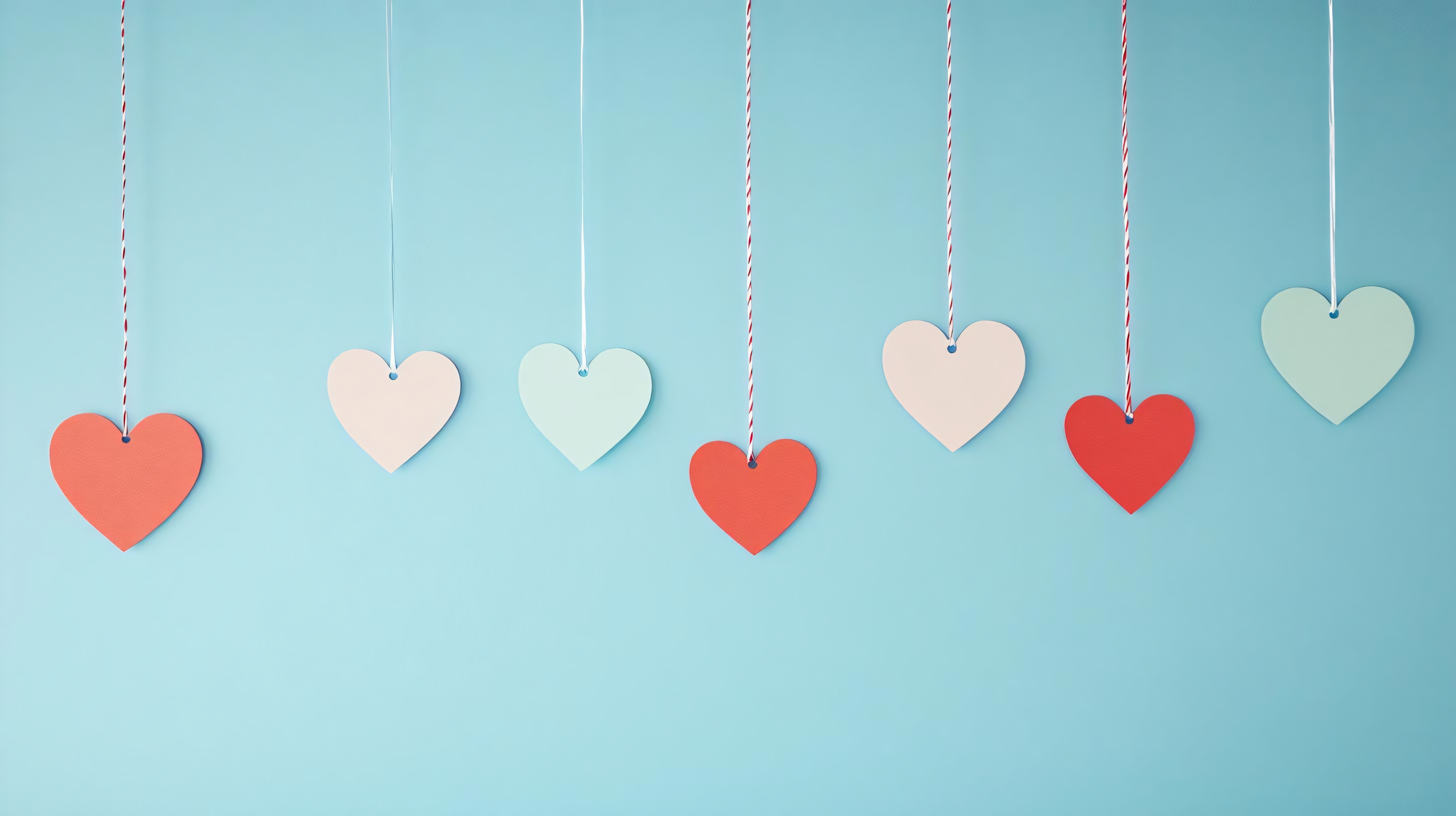 colorful paper hearts hanging on strings for valentine's day background