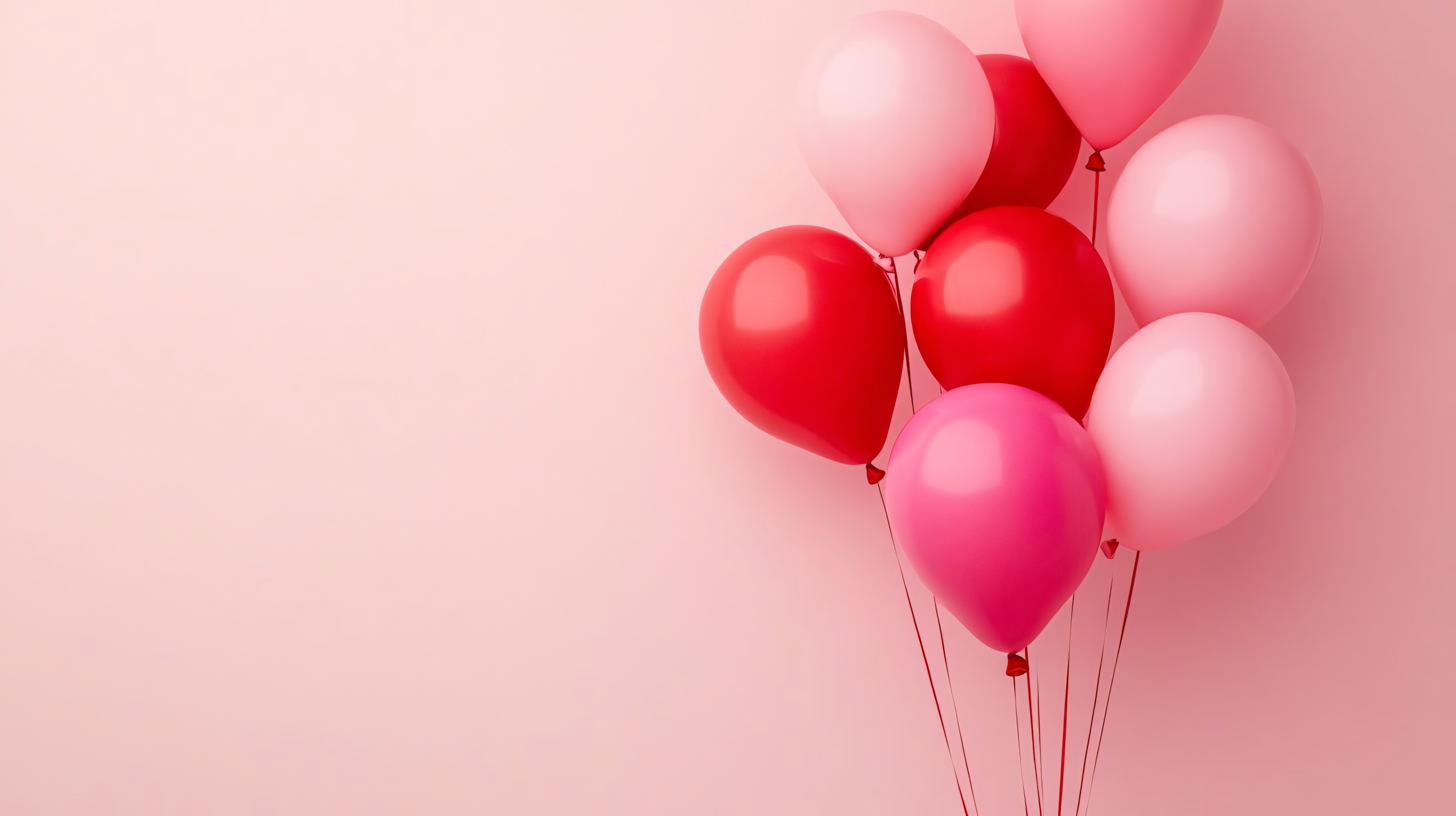 pink and red balloons on string against soft pink background