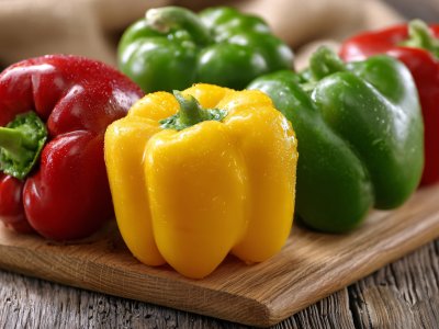 colorful bell peppers on a wooden cutting board