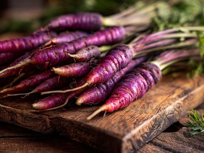 fresh purple carrots on wooden table for healthy vegetable cooking