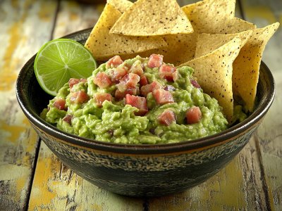 fresh guacamole with tortilla chips and lime wedge