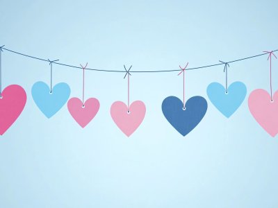 colorful hanging hearts on string against light blue background